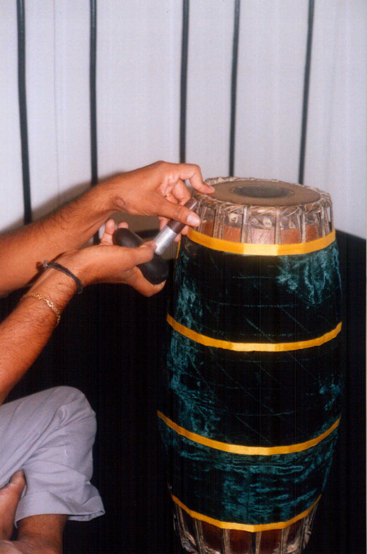 How to tune mridangam - tapping below skin with wood to decrease pitch and lower sruti